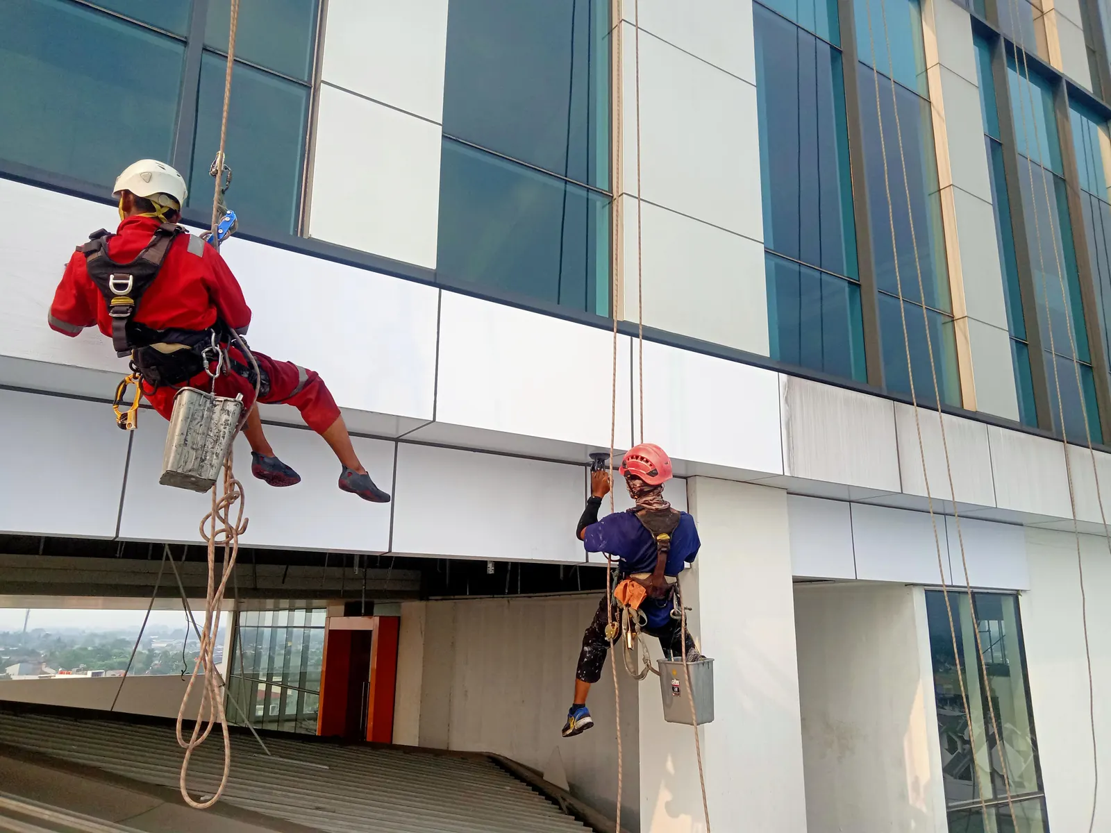 Teknisi rope access pada fasad Esa Unggul